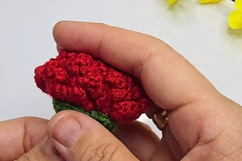 Red crochet rose pressed into the green cup on the skewer