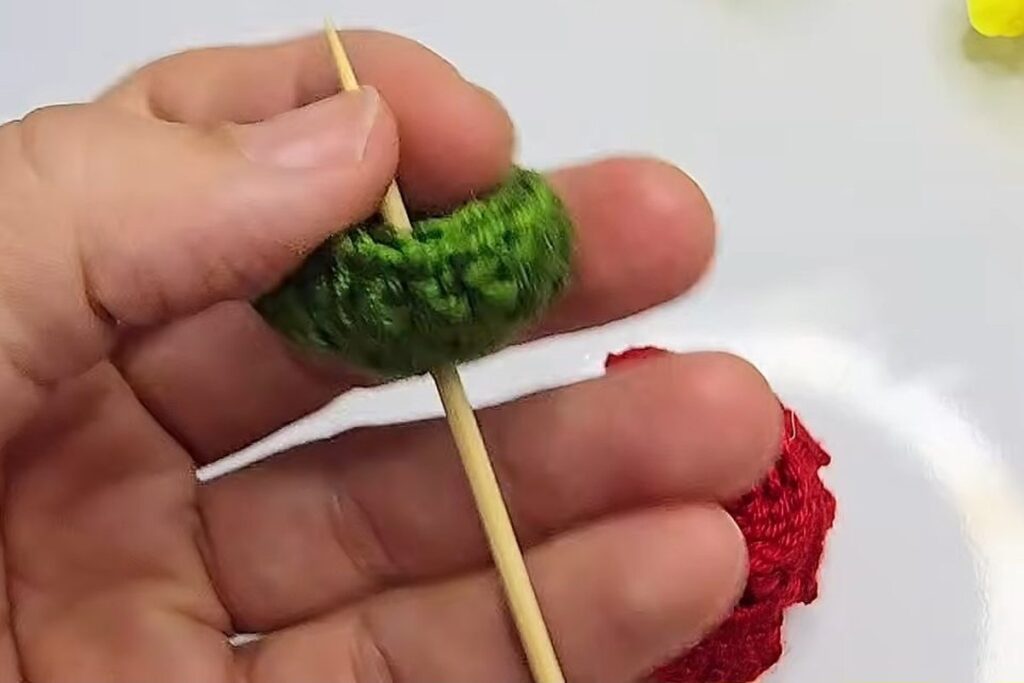 Wooden skewer pushed through the green crochet cup