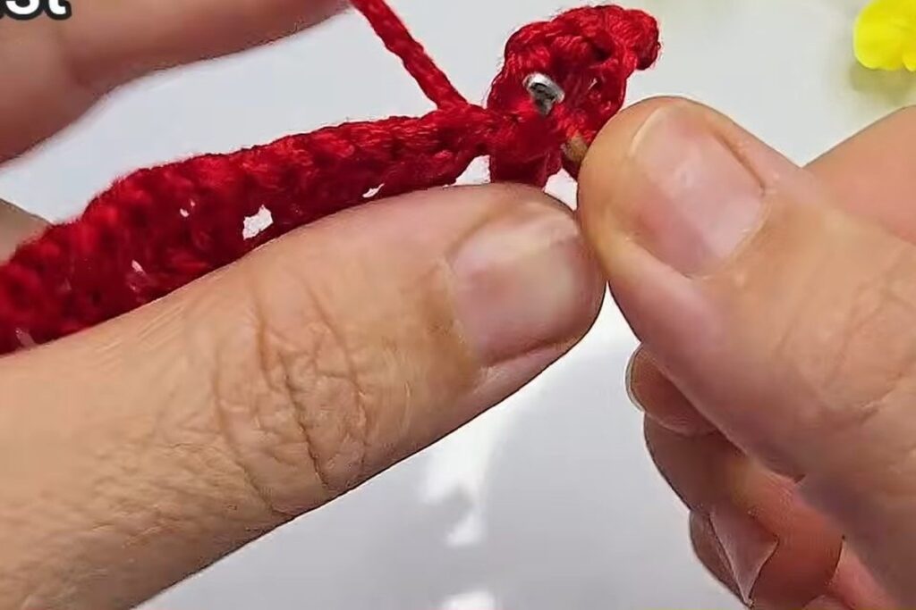 Slip stitch closing a petal on the crochet flower with stem strip