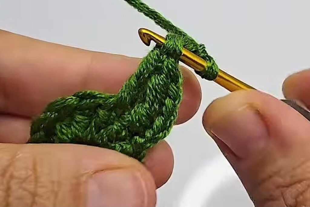 Slip stitch closing the tip of a green crochet rose leaf point