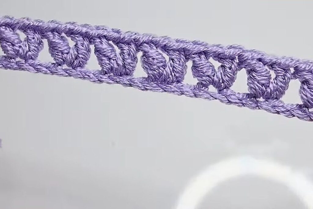 Finished row of V-stitches forming the base strip of a crochet rose pattern
