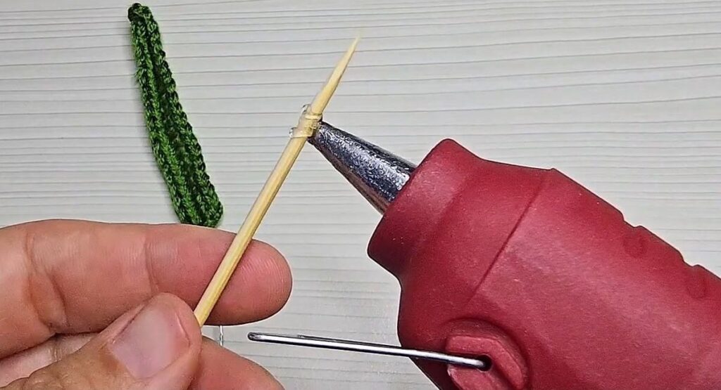 Hot glue on the tip of a wooden skewer before wrapping the stem