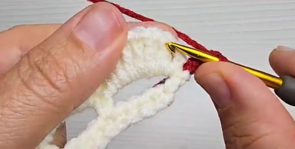 Joining red yarn to the white petal strip of a crochet rose with stem
