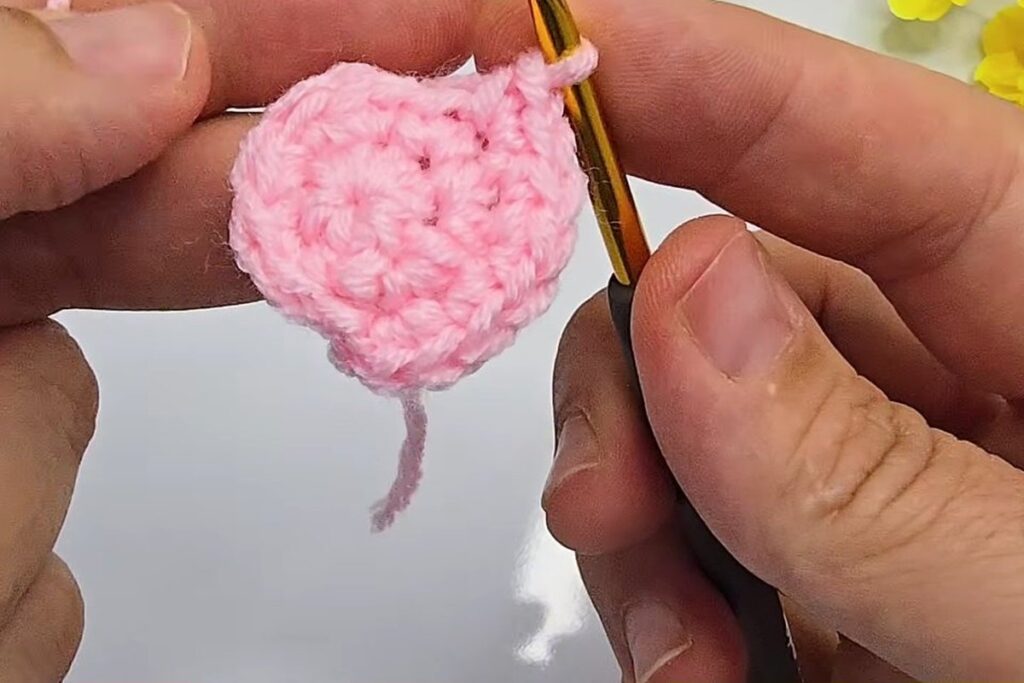 Pink crochet circle after round 3 with 18 stitches