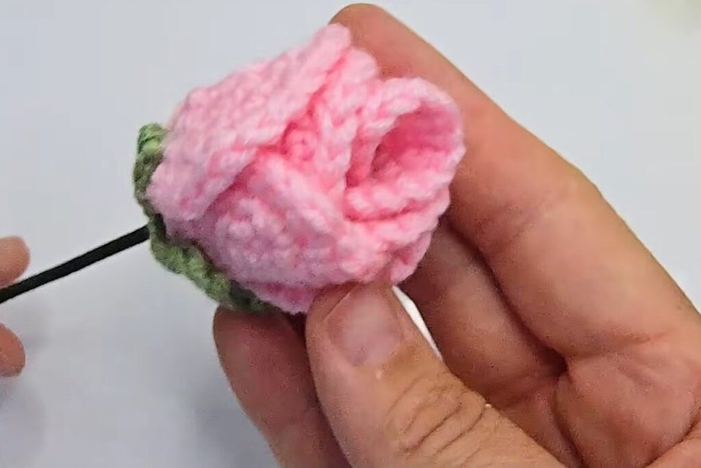 Side view of the finished crochet rosebud showing the layered circles