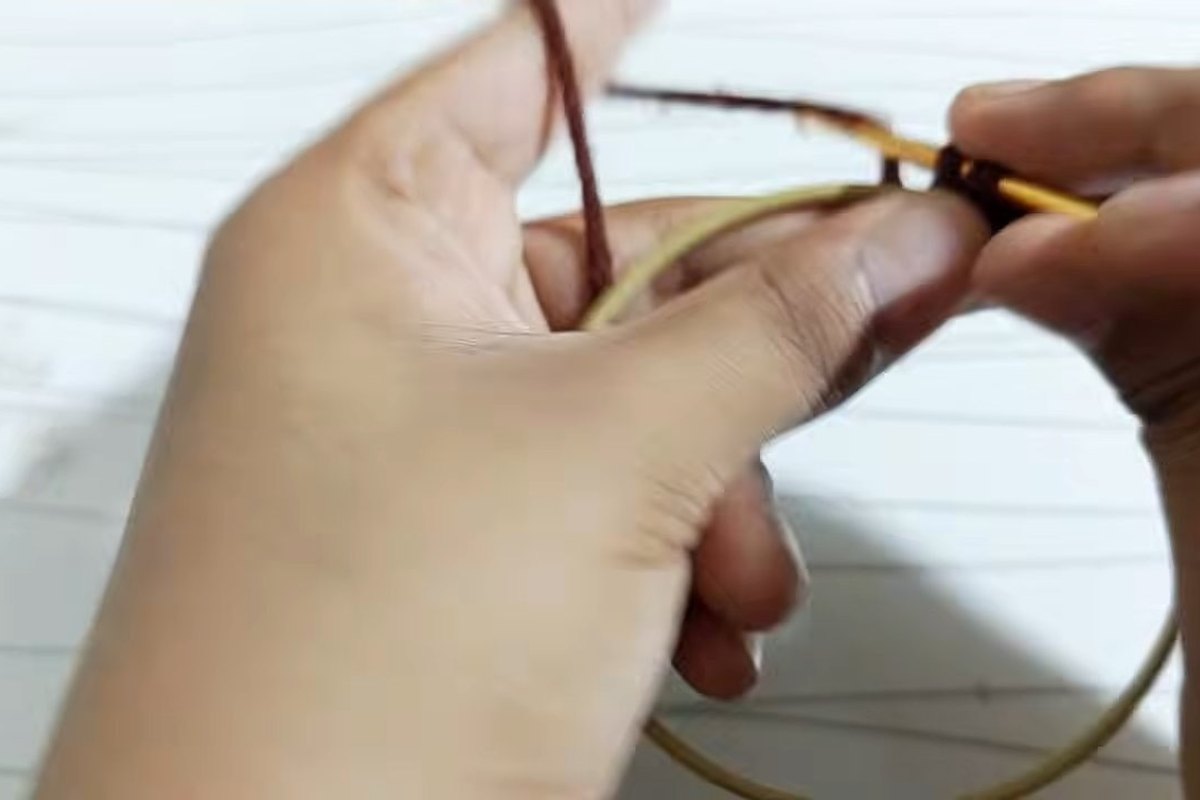 Working single crochet around the metal ring in brown yarn