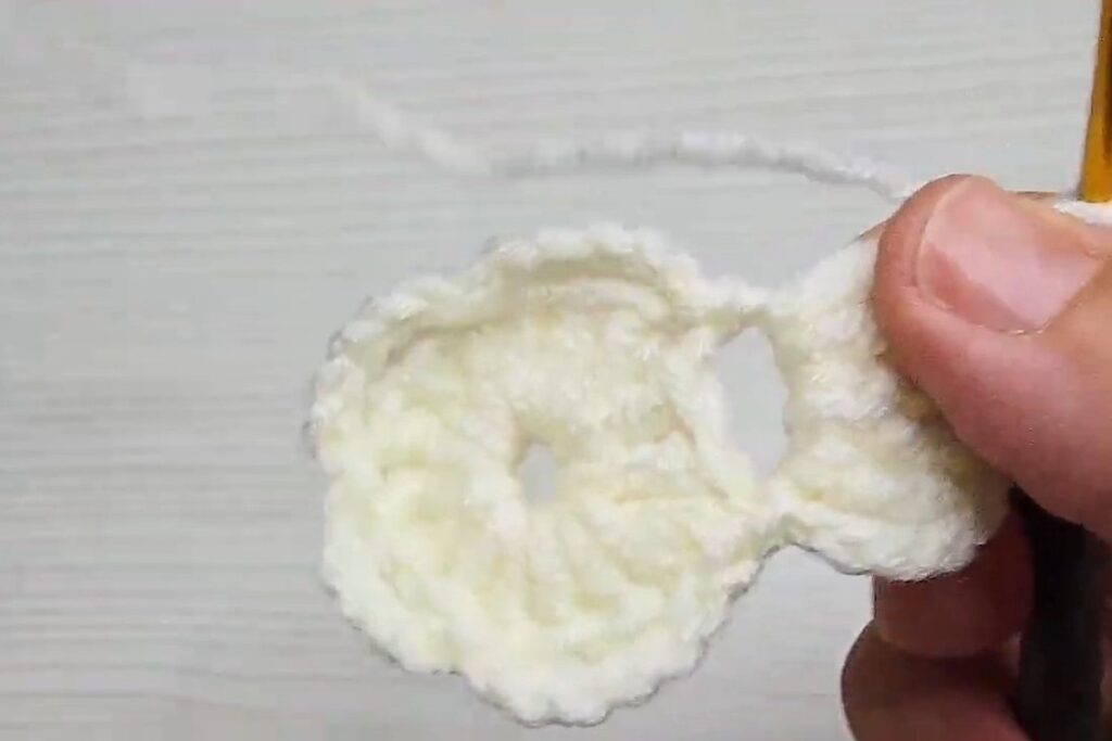 First finished treble crochet petal on the centre disc of a layered crochet flower