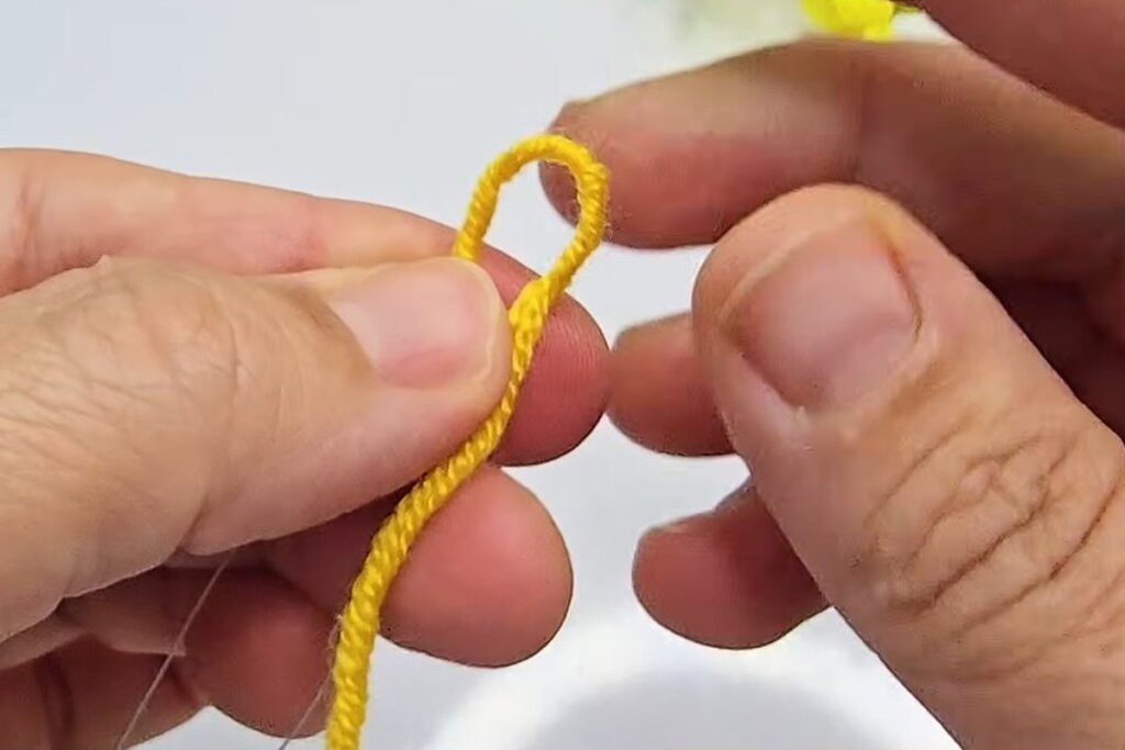 Yellow yarn folded into a loop at the tip of the wire