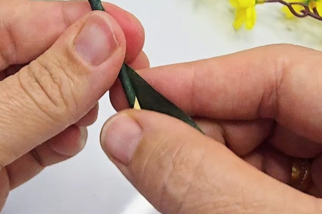 Green stem tape spiralling down over the toothpick and wires