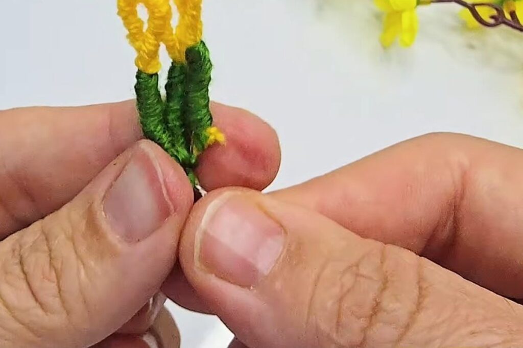 Three yellow-tipped stamens with green wrapped stalks twisted together