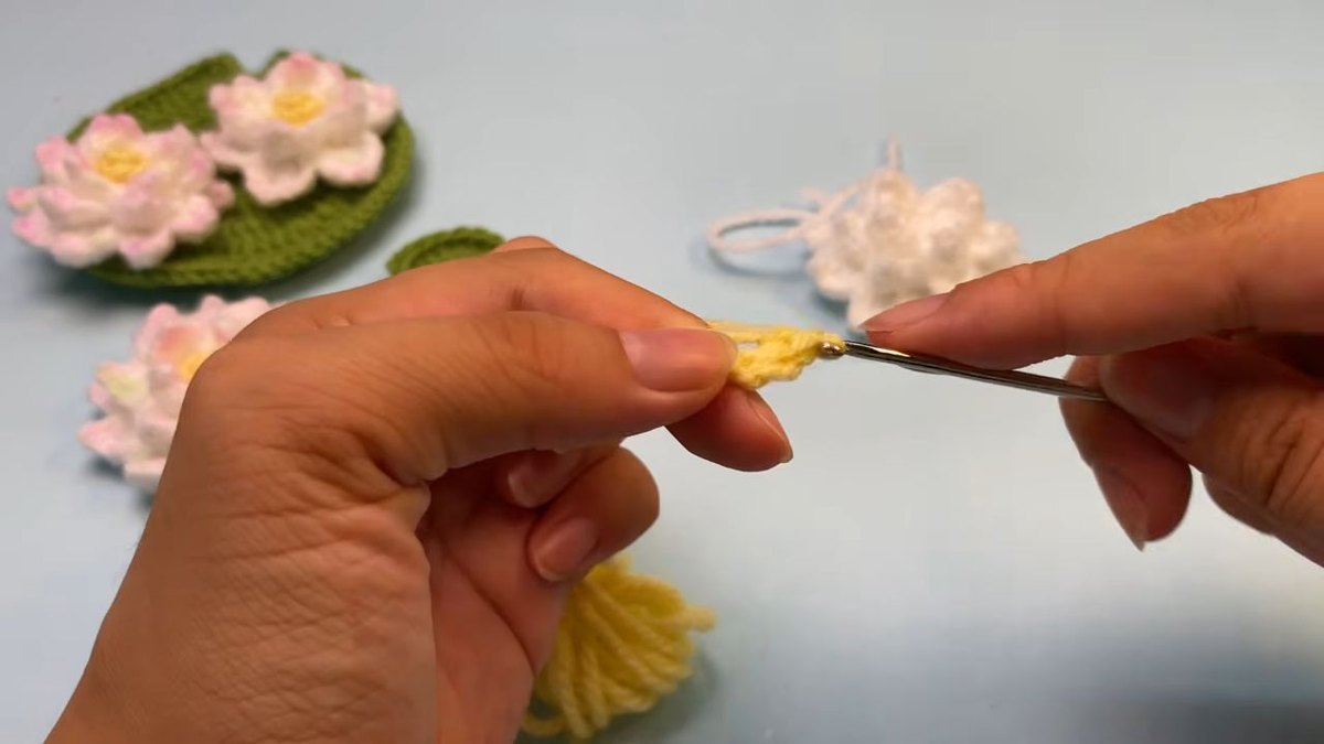 Yellow yarn worked into a magic ring to start the centre bulb of a crochet lotus flower