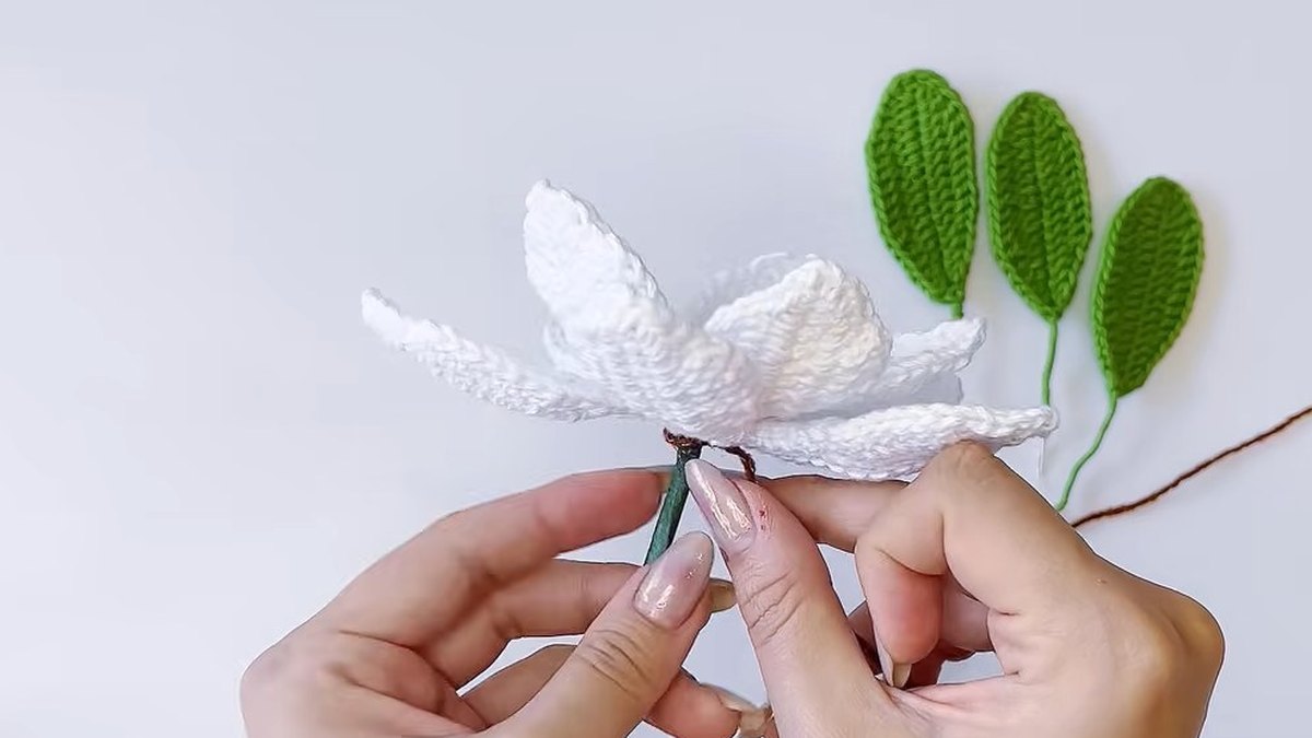 Brown thread being wound round the taped stem of the crochet magnolia flower