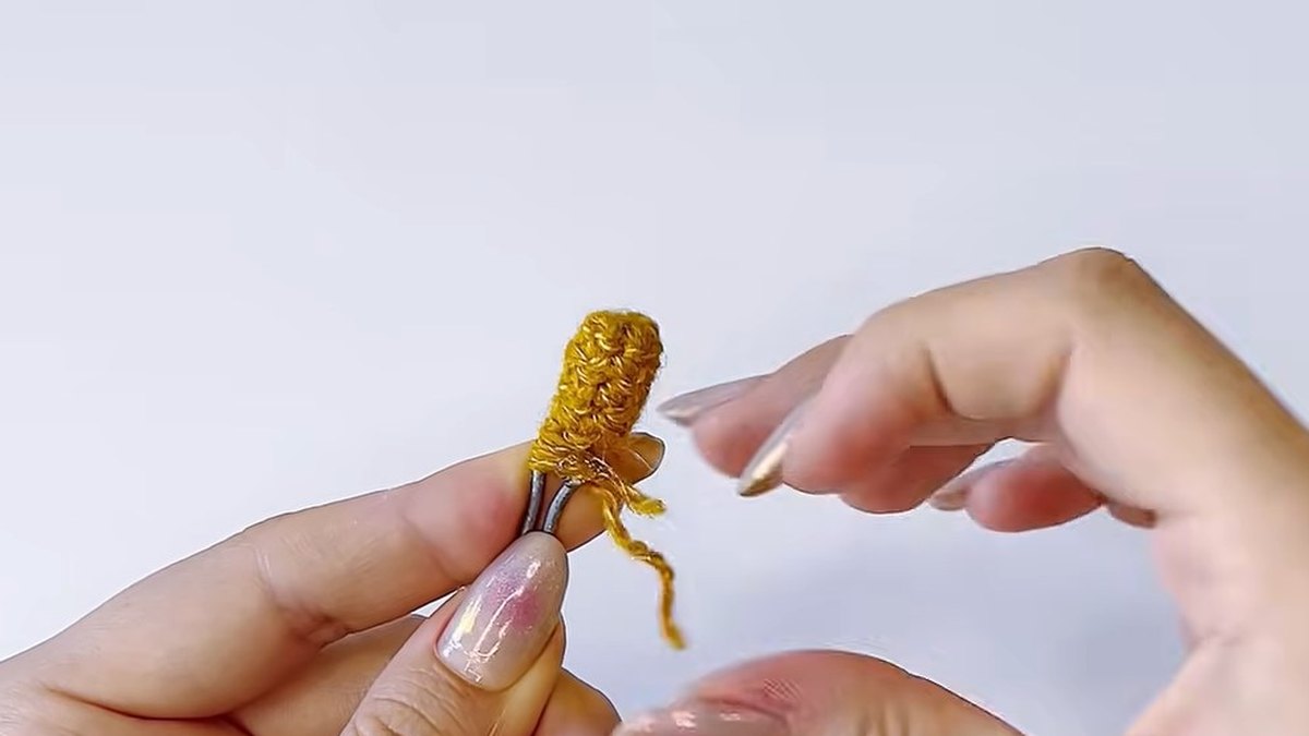 Gold crochet pistil fixed on a wire with the thread wrapped round it and glue on the base