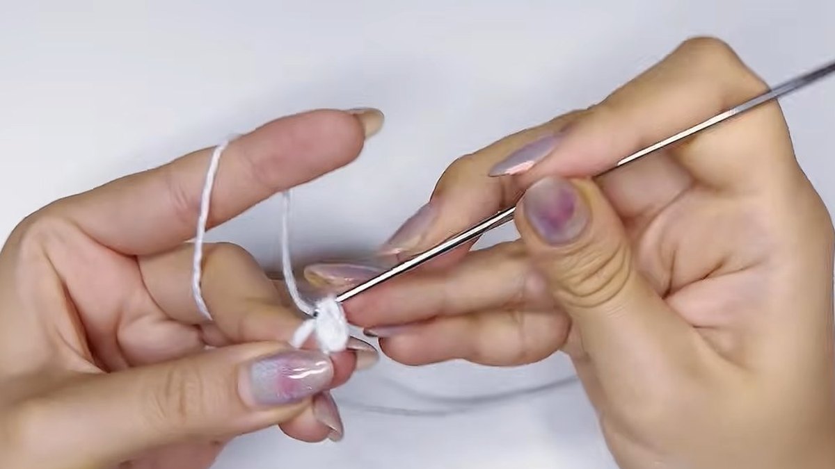 Hook working into a small magic ring of white thread to start the large crochet magnolia flower