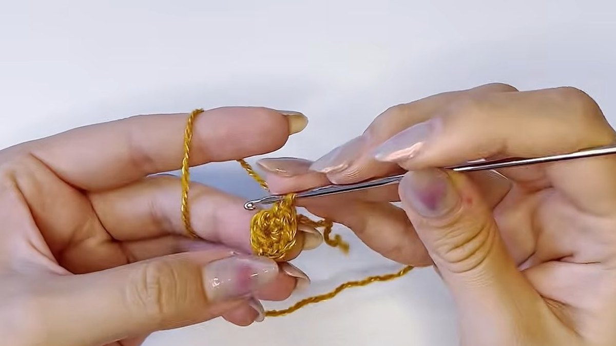 Small gold crochet tube growing round a hook for the pistil of the crochet magnolia flower
