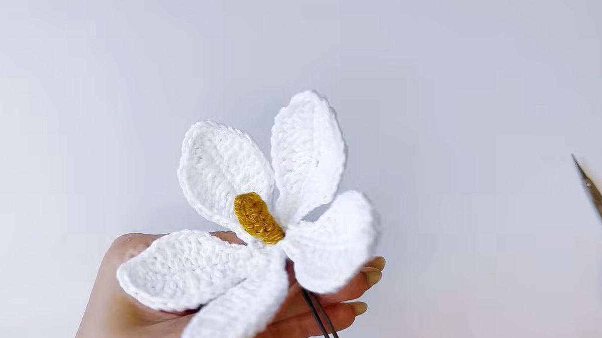 Small white crochet flower slid onto the stem wire below the gold pistil