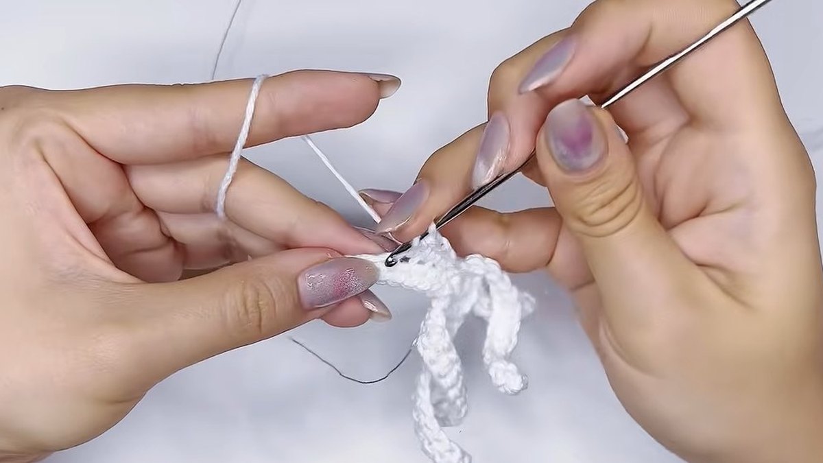 White strip with its first side being shaped over a wire in the small crochet magnolia flower