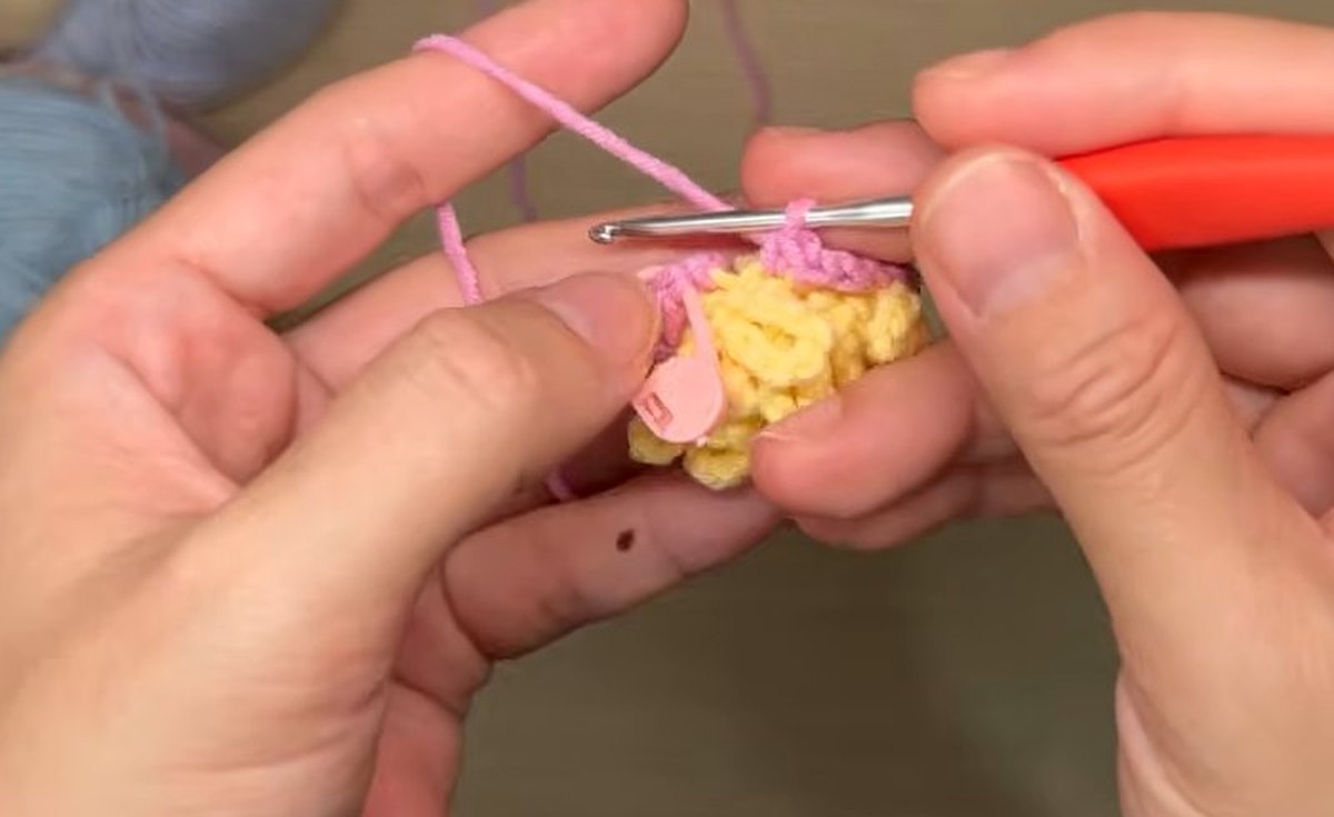 Pink single crochet round worked into the back loops behind the yellow pistil of the crochet peony flower