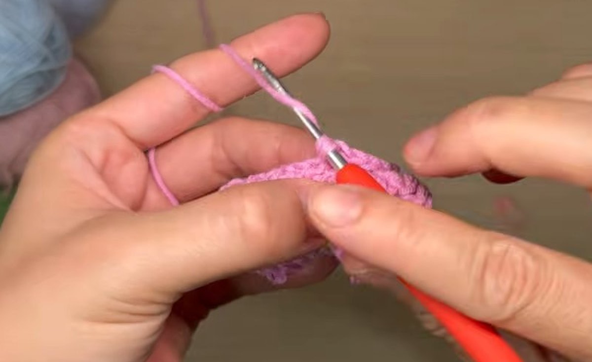 Back loops of the first layer being worked with increases to start the second layer of the crochet peony flower
